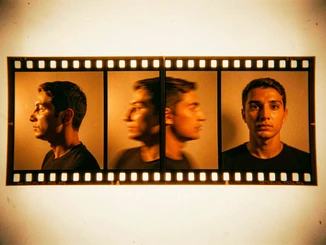 A film strip laid flat on a light table showing four sequential frames of a person turning their head from profile to full face, each frame sharply in focus with consistent warm tungsten lighting. The frames show natural motion blur between positions. Style: analog film contact sheet aesthetic. Mood: dynamic and cinematic.